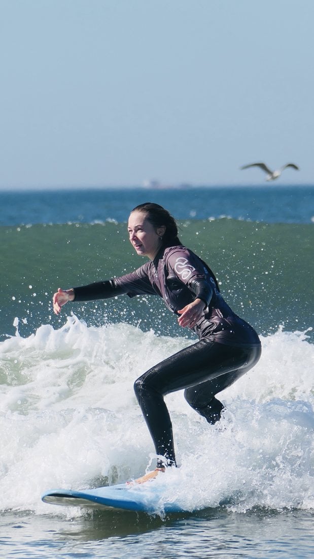 A student riding a wave during a lesson in Porto