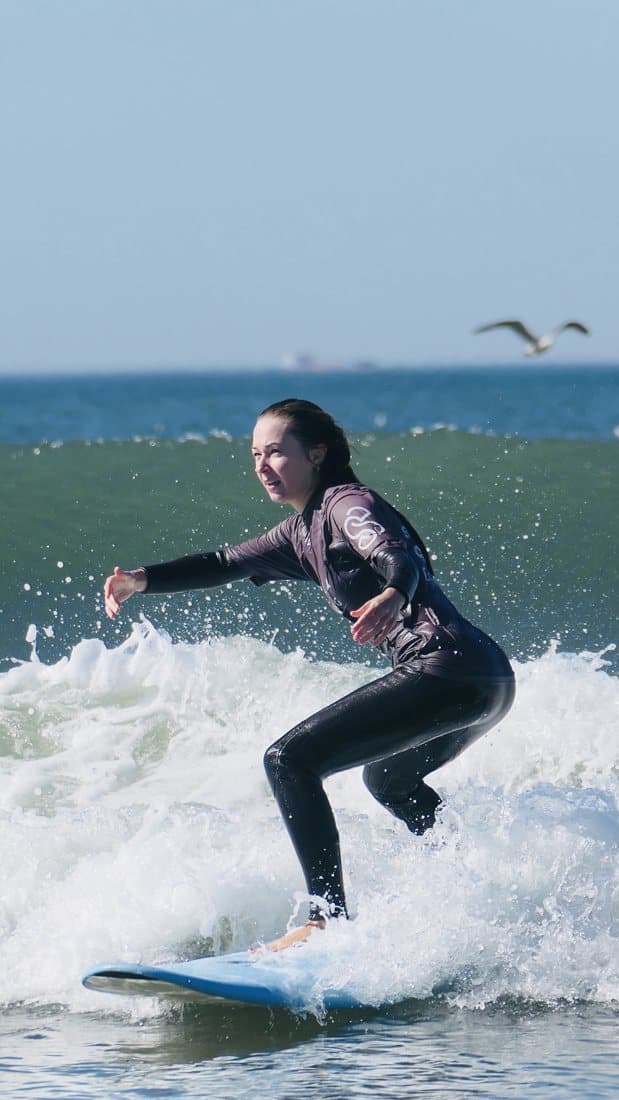 A student riding a wave during a lesson